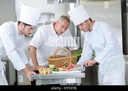 Koch beobachten Lehrling Hacken Gemüse Stockfoto