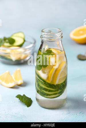 Sommer-Drink mit Gurke, Zitrone, Minze in einer Glasflasche auf blauem Hintergrund Stockfoto