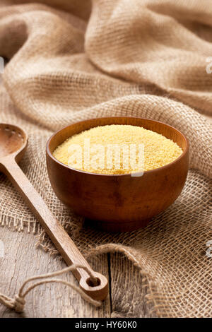 Couscous in einer Holzschale auf einem hölzernen Hintergrund Stockfoto