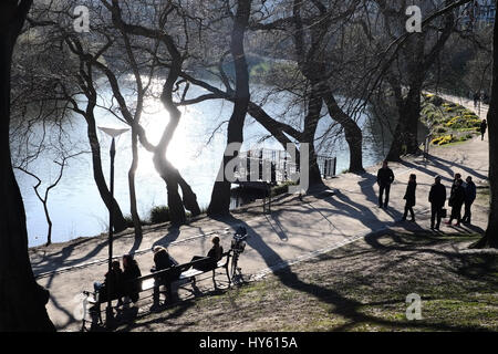 Besucher genießen eine starke Frühlingssonne am Ørstedsparken, einem Stadtpark Center in Kopenhagen, Dänemark Stockfoto