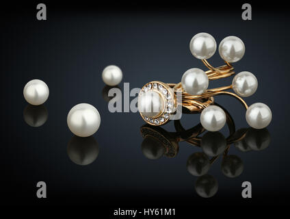 Goldene Ringe mit Diamanten und Perlen auf schwarz Stockfoto