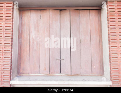 Die alten Holzfenster vor dem Hintergrund der Backstein-Mauern Stockfoto