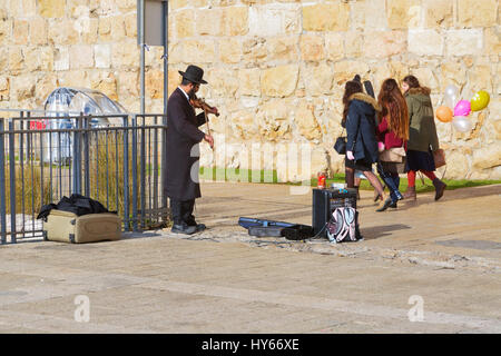 JERUSALEM, ISRAEL - 26. Dezember 2016: Ein jüdischer Mann in orthodoxen Kleidung spielt die Violine am Jaffa-Tor in der Altstadt von Jerusalem. Stockfoto