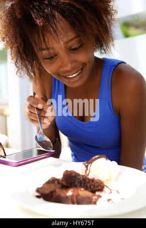Porträt einer schwarzen Frau essen Schokolade Kuchen Stockfoto