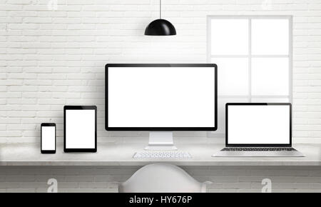 Mehrere Geräte am Schreibtisch für ansprechende Website-Design-Präsentation. Weiße Mauer im Hintergrund. Stockfoto