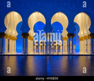Vereinigte Arabische Emirate, ABU DHABI - ca. Januar 2017: Pool, Bögen und Säulen der Sheikh-Zayed-Moschee in der Nacht. Stockfoto