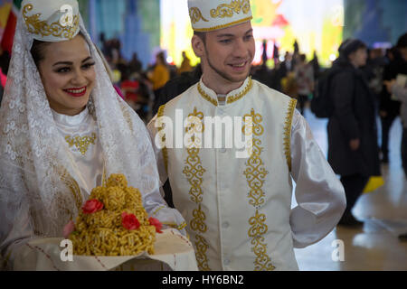 Paar in nationalen Tatar Kleidung mit Tatar nationalen Gericht Chak-Chak während der Feier Nowruz auf Moskauer Messegelände VDNH, Russland Stockfoto