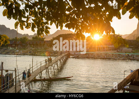 Holzbrücke über Nam Song River während des Sonnenuntergangs im Dorf Vang Vieng, Laos Stockfoto