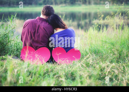 Flitterwochen in Lagunen mit Papierherz genießen. Hipster-paar in Liebe umarmt. Valentines Day. Stockfoto