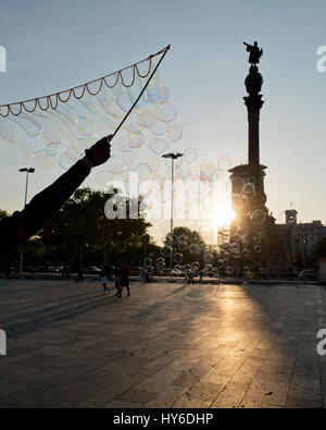 Streetart-Künstler Seifenblasen in Richtung Abendsonne am Plaça Portal De La Pau, Mirador de Colón, Barcelona, Katalonien, Spanien Stockfoto
