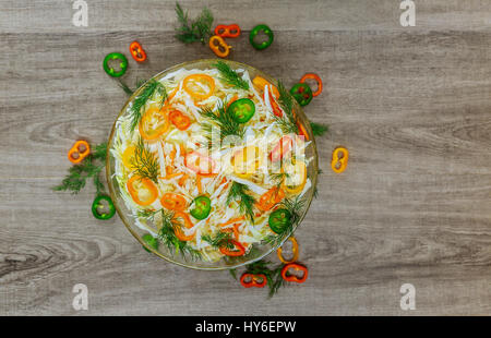 Gesunde wenig Kalorien Frühling Krautsalat mit Paprika, Mais und Dill auf einem weißen Teller auf einem alten rustikalen Tisch, Ansicht von oben Stockfoto