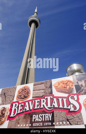 CN Tower blickt gegen den Himmel mit einem BeaverTails frittierten Teigwagen, Street Food und zwei kanadischen Ikonen im CN Tower Toronto, Ontario, Kanada. Stockfoto