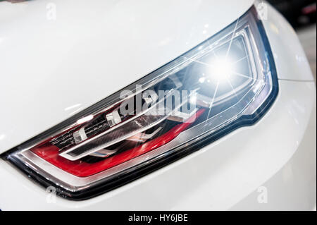Closeup auf ein Scheinwerfer des weißen Sports Auto Stockfoto