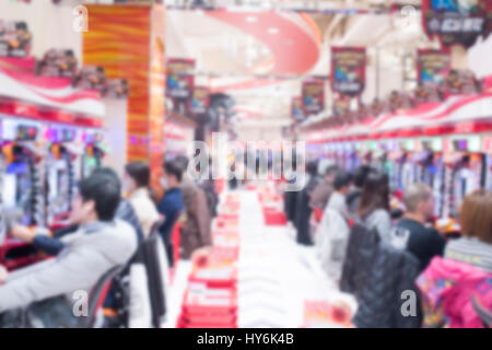 Verschwommene Menschen spielen Pachinko Spielautomaten in Tokio Stockfoto