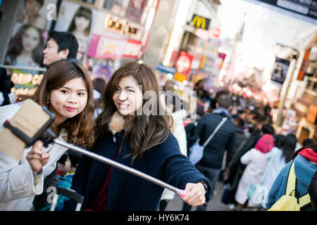 Tokyo, Japan - 10. Januar 2017: Japanische Touristen Mädchen Selfie vor Takeshita Street in Harajuku, Japan nehmen.  Takeshita Street ist die f Stockfoto