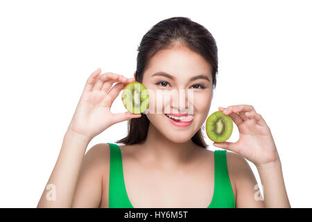 Tropische Früchte. Gesunde Ernährung. Charmante junge Asiatin halten frische saftige Kiwi und lächelt. Grünen Hintergrund. Stockfoto