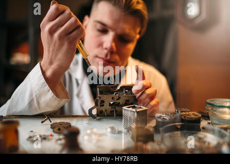 Uhrmacher Öl schmiert den Mechanismus der alten Uhr. Reparatur von mechanischen Uhren Stockfoto