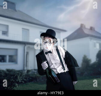 Pantomime mit großen Flasche Alkohol einen betrunkenen Mann durchführen. Comedy-Pantomime-Künstler im Anzug, Handschuhe, Brille, Make-up Maske und Hut Stockfoto