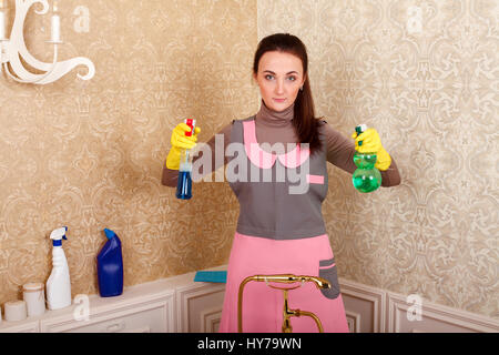 Frau in Uniform und Gummihandschuhe Reinigungsmittel in den Händen halten. Zimmermädchen-Konzept Stockfoto