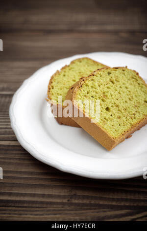 Lbs-Kuchen mit Tee Matcha auf Platte über hölzerne Hintergrund Stockfoto