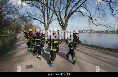 Hamburg, Deutschland. 26. März 2017. Feuerwehr führen durch Max Plettenberg (c) trainieren für einen Marathon-Lauf entlang der Außenalster in Hamburg, Germany, 26. März 2017. Die Feuerwehr sammeln Spenden für gemeinnützige Projekte mit dem Lauf. Foto: Axel Heimken/Dpa/Alamy Live News Stockfoto