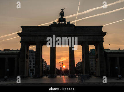 Die aufgehende Sonne Silhouetten am Brandenburger Tor in Berlin, Mitteldeutschland, 2. April 2017. Foto: Paul Zinken/dpa Stockfoto