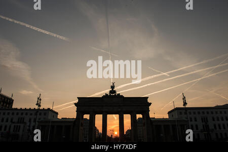 Die aufgehende Sonne Silhouetten am Brandenburger Tor in Berlin, Mitteldeutschland, 2. April 2017. Foto: Paul Zinken/dpa Stockfoto