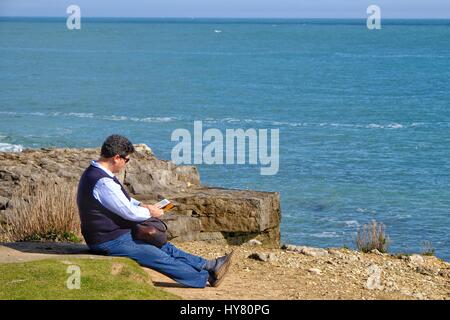 Portland Bill, Dorset, UK. 2. April 2017. Ein Besucher liest und genießt die Sonne als Menschen strömen in Portland Bill in das anhaltend gute Wetter. Bildnachweis: Tom Corban/Alamy Live-Nachrichten Stockfoto