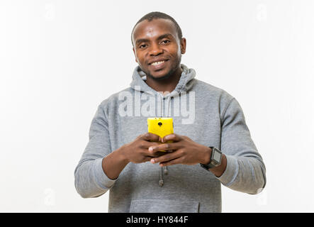 Ein Afrikaner benutzt ein Handy in einer Studioumgebung. Stockfoto