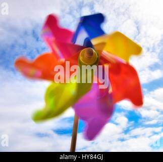 Buntes Spielzeug Windmühle gegen die Sonne und blauer Himmel. Stockfoto