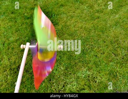 Buntes Spielzeug Windmühle im Hintergrund Rasen. Stockfoto