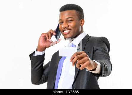 Ein Afrikaner spricht auf einem mobilen Gerät in einem Studio-Setting. Stockfoto