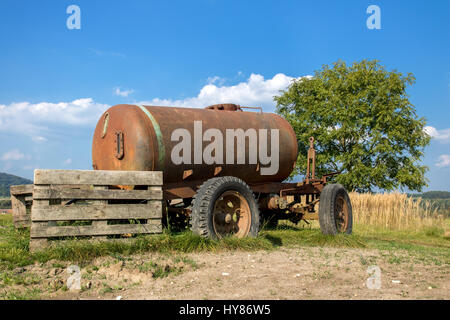 Alten mobile Zisterne mit Wasser auf dem Land. Verlassene alte rostige Auto Anhänger Tank im Feld. Stockfoto