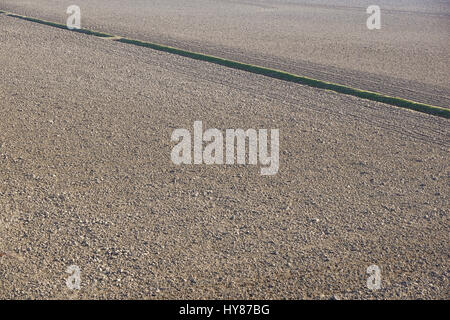 Top Luftbild von Furchen Zeilenmuster in ein gepflügtes Feld, die Pflanzen im Frühjahr vorbereitet. Wachsende Weizenernte im Frühling. Stockfoto