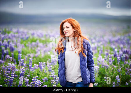 Glückliche, selbstbewusste junge Frauen in einem Feld von lila Blüten im Süden Islands Stockfoto