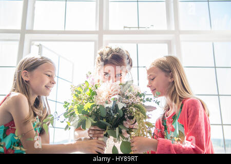 Eine Braut mit ihrem Zwilling Brautjungfern hält einen Blumenstrauß vor ihrer Hochzeit Stockfoto