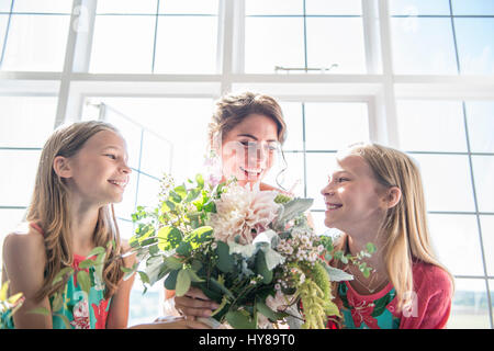 Eine Braut mit ihrem Zwilling Brautjungfern hält einen Blumenstrauß vor ihrer Hochzeit Stockfoto