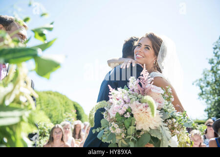 Eine Braut und Bräutigam an ihrem Hochzeitstag zu umarmen Stockfoto