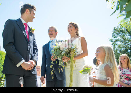 Stolzer Vater geht seiner Tochter den Gang hinunter, am Tag ihrer Hochzeit Stockfoto