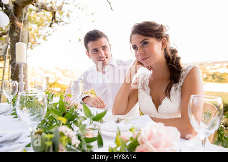 Eine Braut und Bräutigam sitzen am Tisch bei einem externen Hochzeit Stockfoto