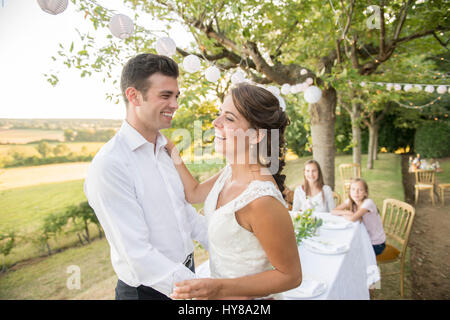 Eine Braut und Bräutigam amüsieren sich bei einem externen Hochzeit Stockfoto