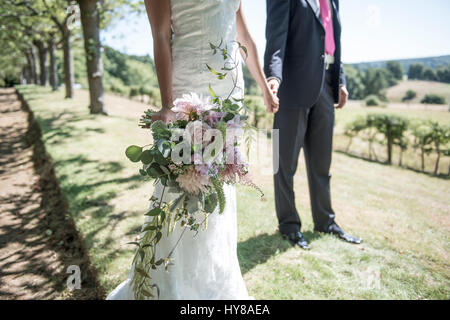 Ein frisch verheiratetes Paar stehen Hand in Hand am Tag ihrer Hochzeit Stockfoto