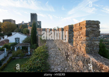 Óbidos, Portugal: Gehweg entlang der Festungsmauer führt zu der mittelalterlichen Burg von Óbidos. Stockfoto