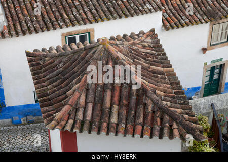 Óbidos, Portugal: Skurrile Terrakotta Dach auf ein Haus im alten Dorfkern. Stockfoto