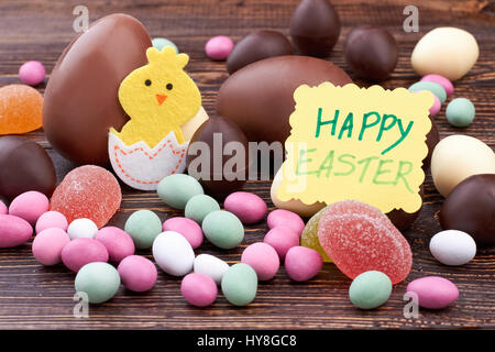 Glücklich Osterkarte und Süßigkeiten. Filz Huhn Ausschnitt. Hausgemachte Ostern Süßigkeiten behandelt. Stockfoto