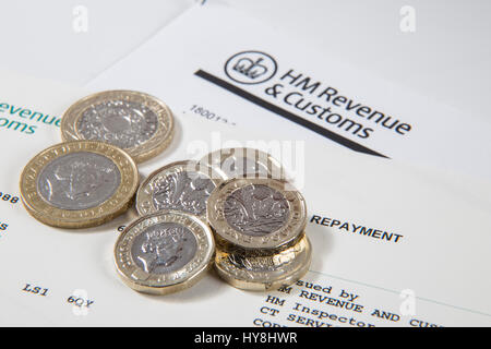 Neue £1 Pfund-Münzen, £2 Pfund-Münzen und £5 Pfund-Noten auf eine HM Einnahmen & Zollbeleg Stockfoto