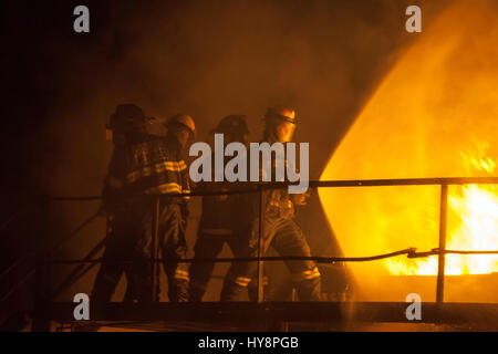 Feuerwehrleute mit voller Spray, löschte Feuer während der Brandbekämpfung Übung Stockfoto