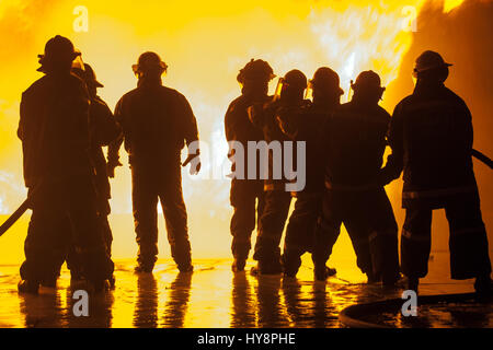 Gruppe der acht Feuerwehrleute während der Übung zur Brandbekämpfung Stockfoto