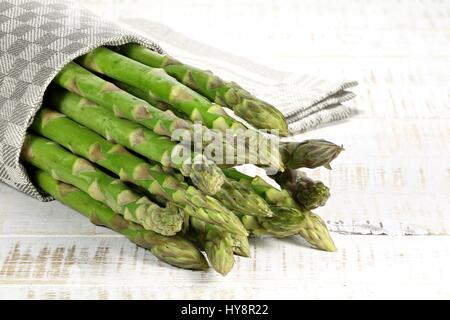 Bündel von grünem Spargel auf hölzernen Hintergrund Stockfoto