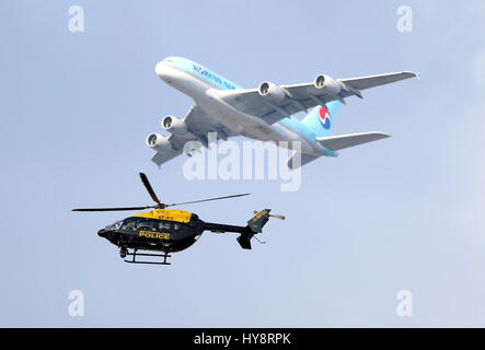 Ein Metropolitan Polizei-Hubschrauber und ein Korean Air Flugzeug gesehen über London Stockfoto